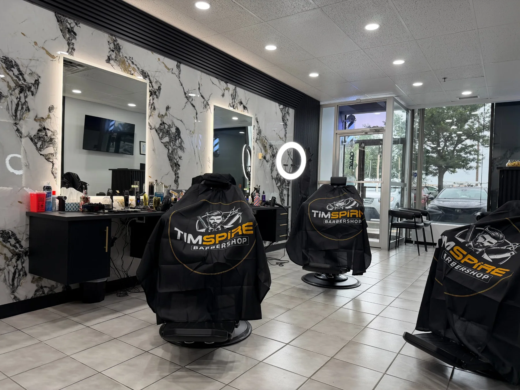 Barber chairs and illuminated mirrors inside Timspire Barbershop