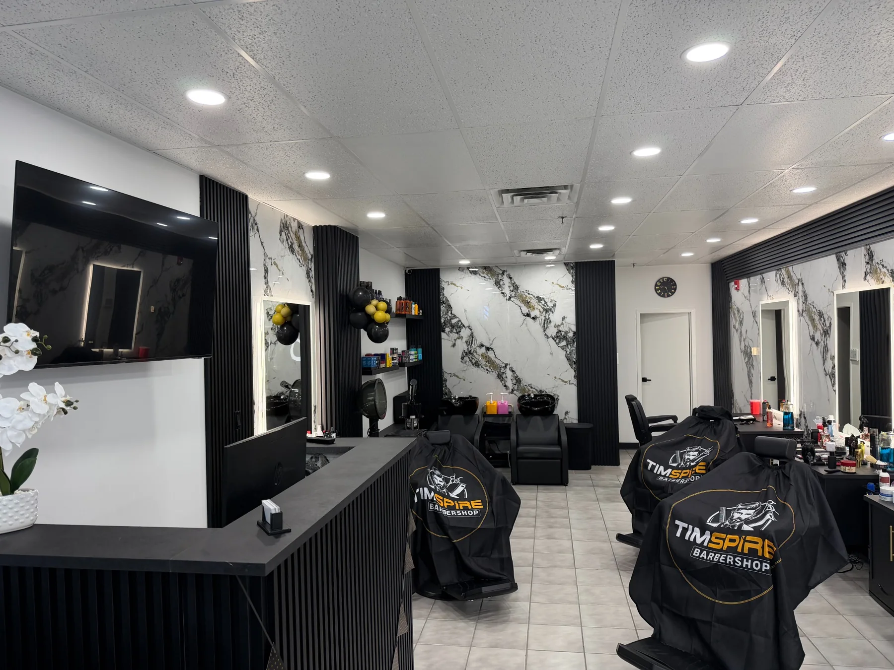 Modern black, white and gold interior of Timspire Barbershop